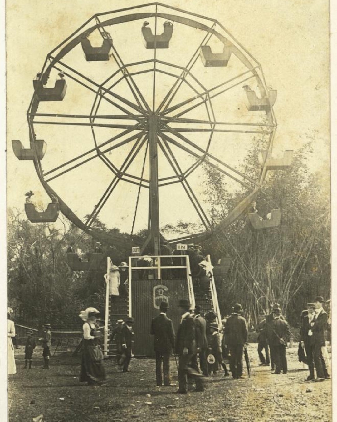 Archival photograph of people gathered beneath a ferris wheel at the Ekka in Brisbane, circa 1918.